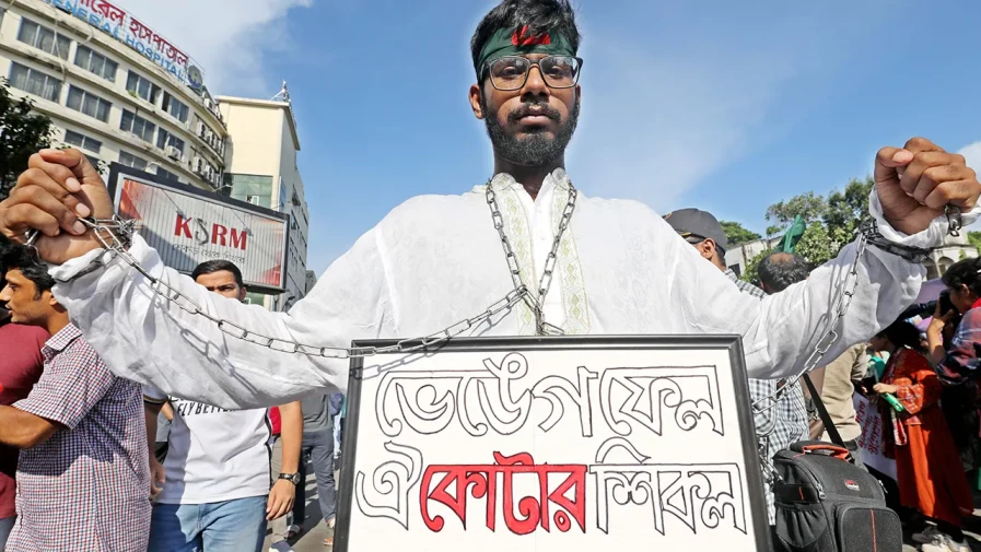 প্রতীকী শিকল পরে কোটার বিরুদ্ধে প্রতিবাদ জানাচ্ছেন এক শিক্ষার্থী।